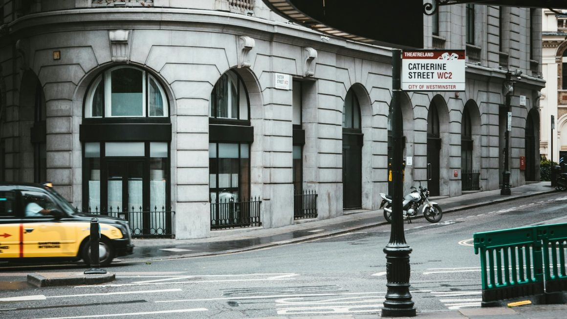 yellow taxi cab on road near building during daytime